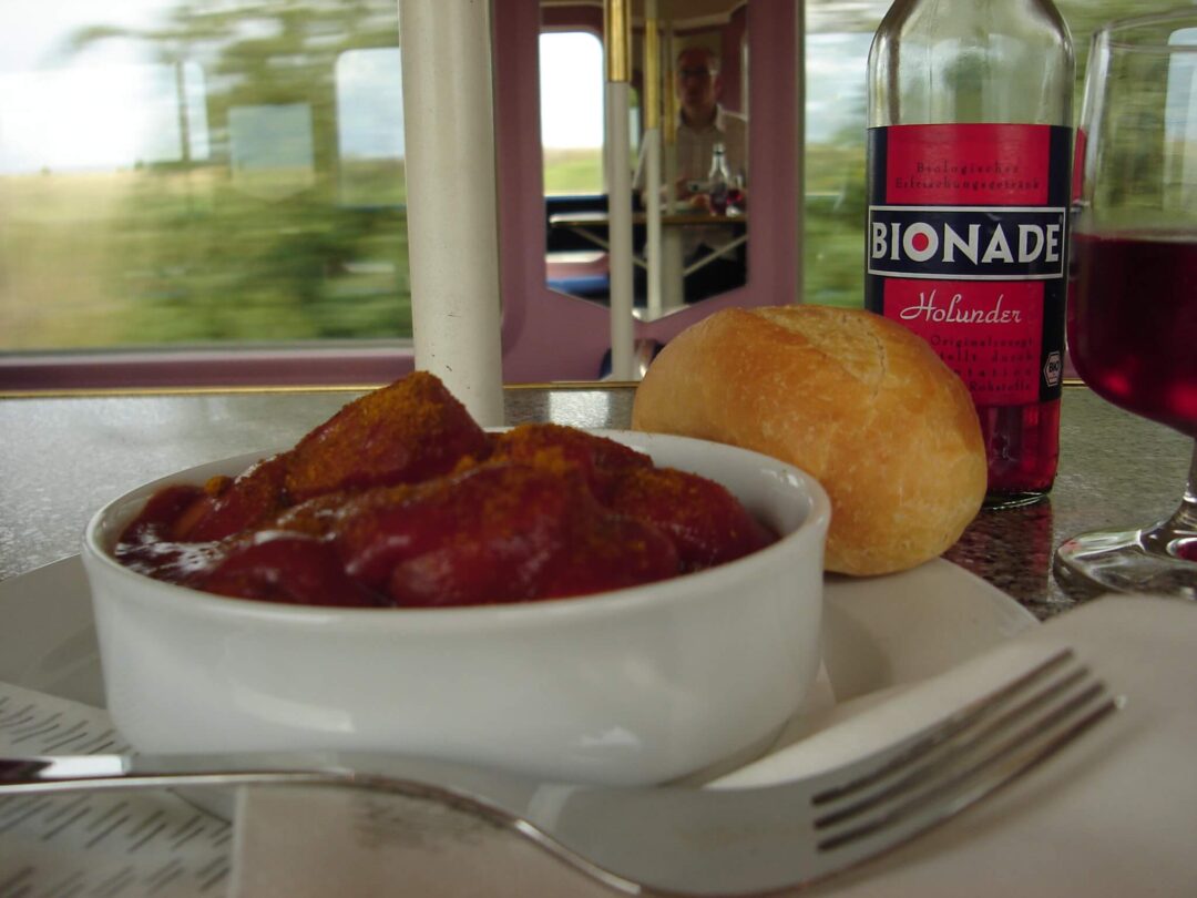 Currywurst mit einem Brötchen und Kaltgetränk im Bordbistro der Deutschen Bahn in einem Zug