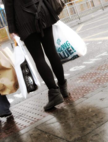 Zwei Frauen mit Einkaufstüten an einer Straße, unter anderem sind die Taschen von der Modekette Primark