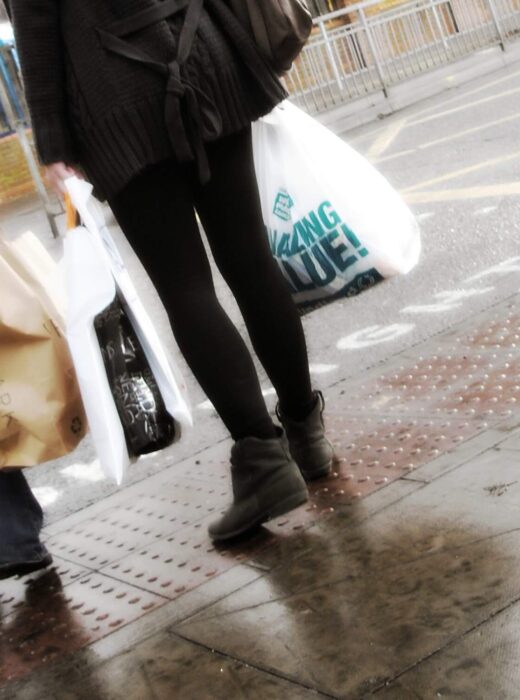 Zwei Frauen mit Einkaufstüten an einer Straße, unter anderem sind die Taschen von der Modekette Primark