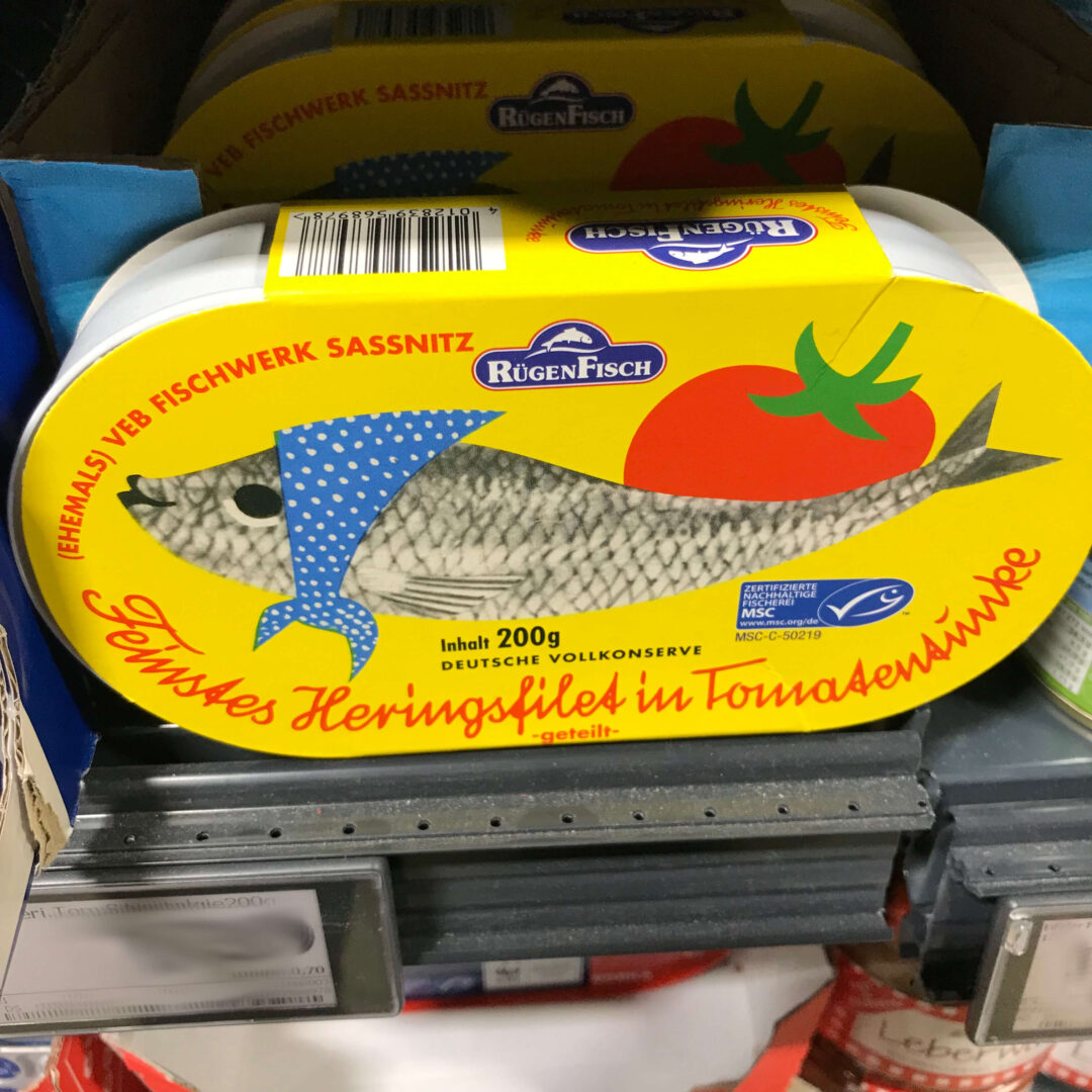 Fisch wird mit Kopftuch verniedlicht dargestellt - toter Fisch in Konserve