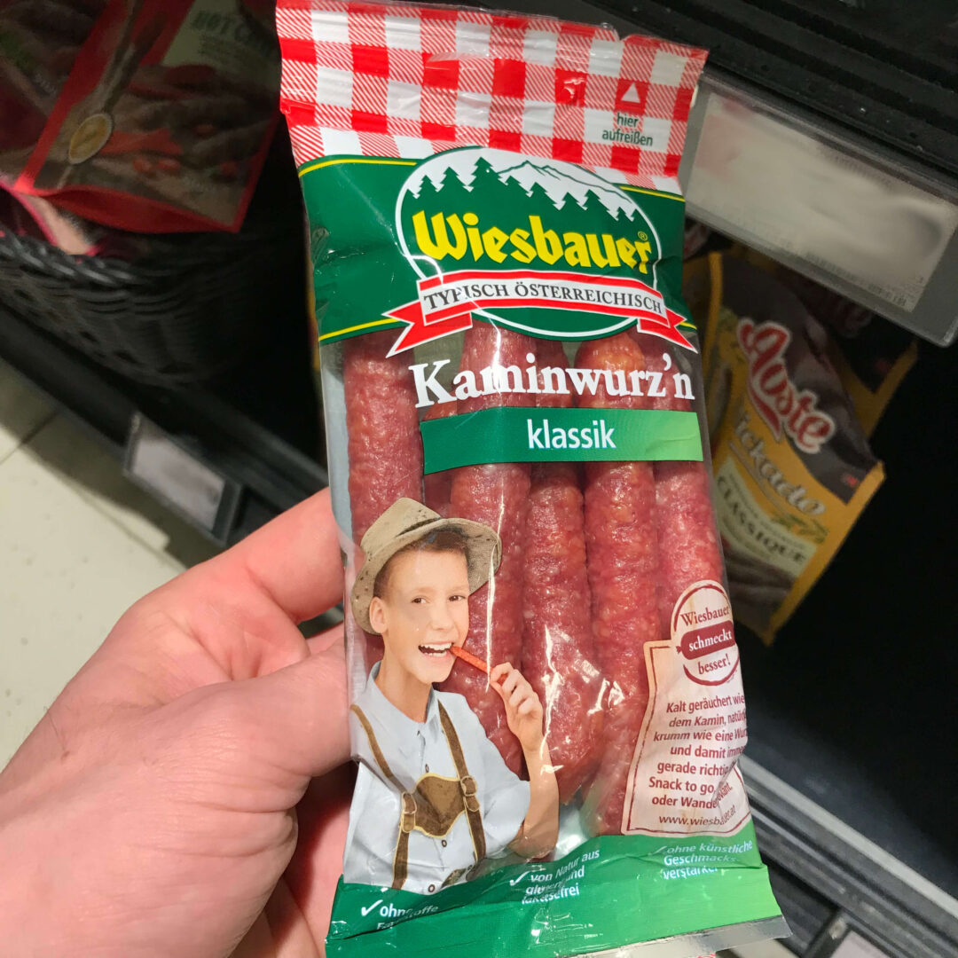 Junge in Trachtenkleidung isst Wurst aus Österreich