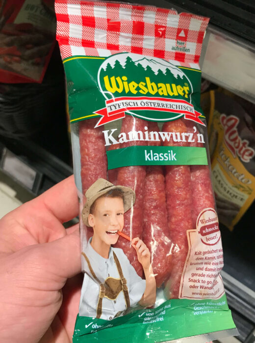 Junge in Trachtenkleidung isst Wurst aus Österreich