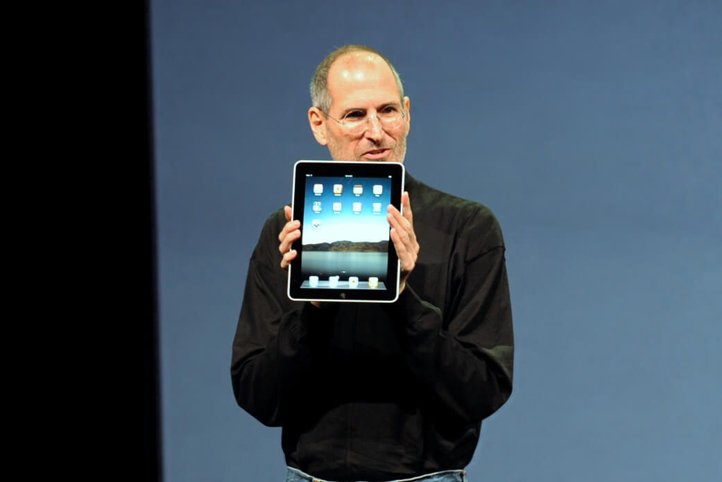 Steve Jobs stellt ein iPad auf einer Bühne öffentlich vor